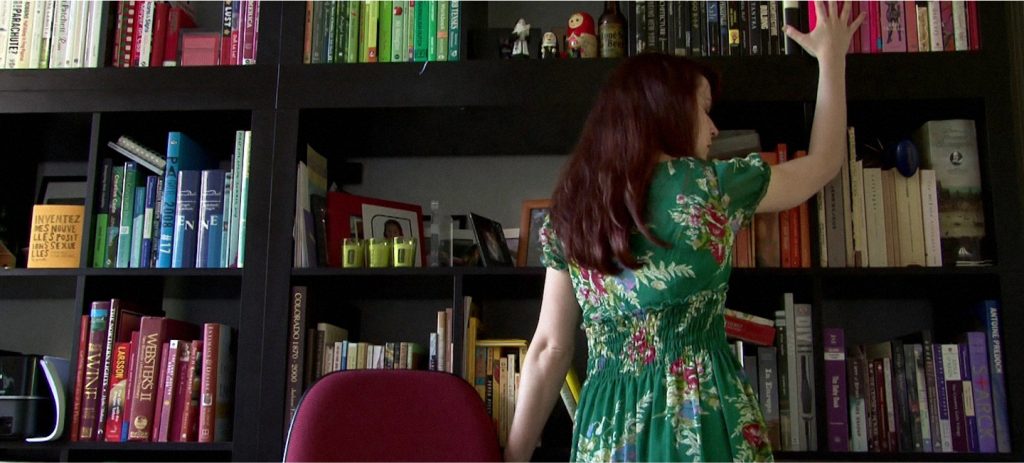 AnnaBelle Lee caresses a bookshelf in Silver Shoes (The Housesitter), an erotic trilogy directed by Jennifer Lyon Bell for Blue Artichoke Films
